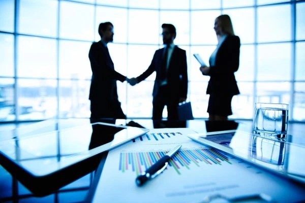 Two business people shaking hands, representing partnership.
